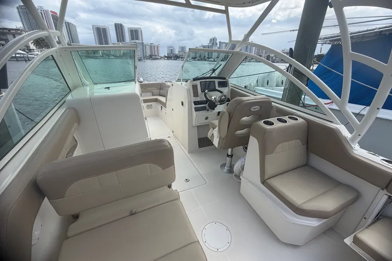 Slide: The Image of 2019 Sailfish 245 DC boat interior with seating and steering, docked in a marina. - 38