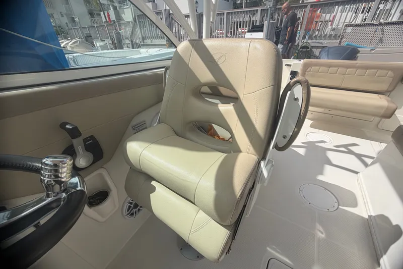 Slide: The Image of 2019 Sailfish 245 DC boat interior with beige captain's chair and steering wheel. - 27