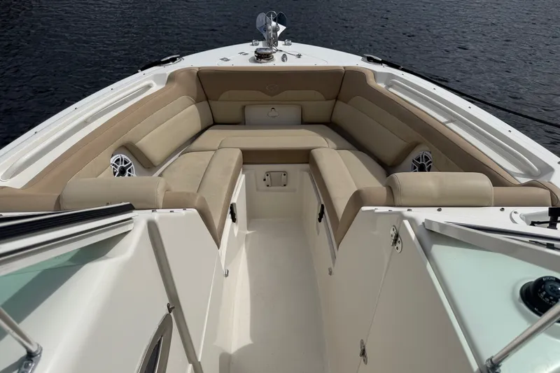 Slide: The Image of 2019 Sailfish 245 DC boat interior with beige seating and speakers, on calm water. - 9