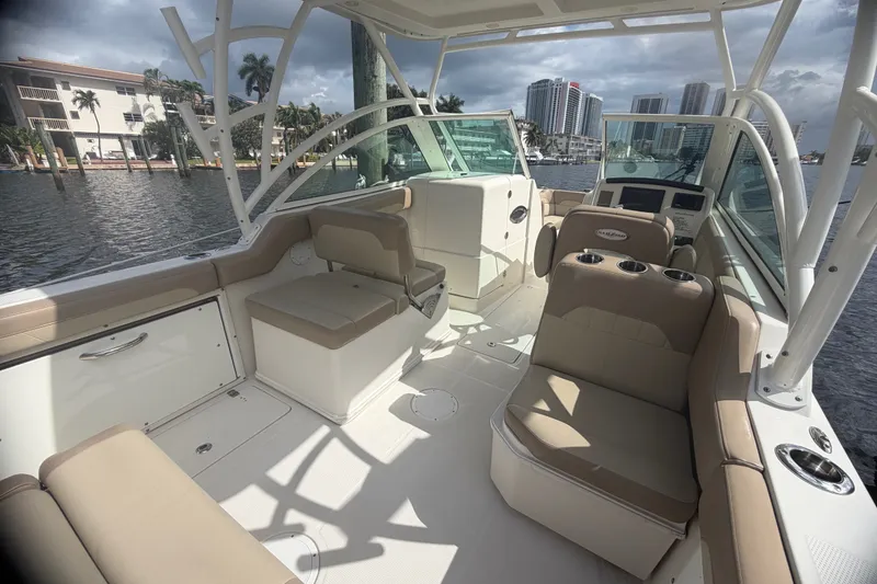 Slide: The Image of 2019 Sailfish 245 DC boat interior with beige seating and waterfront view. - 31