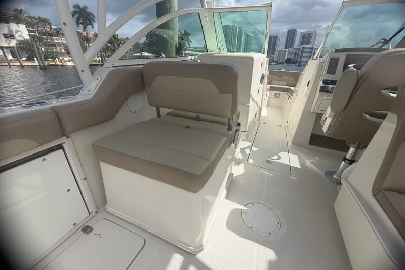 Slide: The Image of 2019 Sailfish 245 DC boat interior with beige seating and modern dashboard. - 33