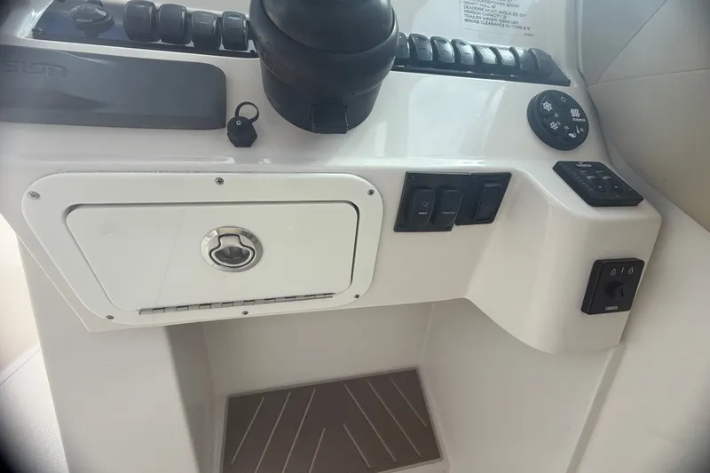 Slide: The Image of Control panel of a 2019 Sailfish 245 DC boat with switches and storage compartment. - 22