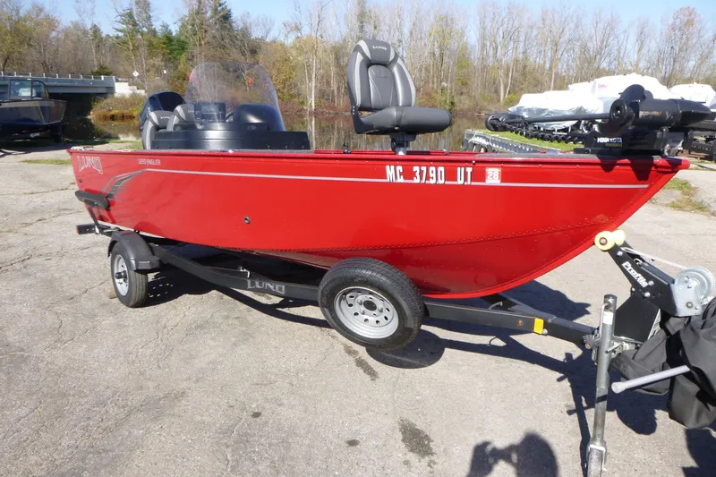 Slide: The Image of 2022 Lund 1650 Angler SS boat in vibrant red on a trailer, parked outdoors. - 1