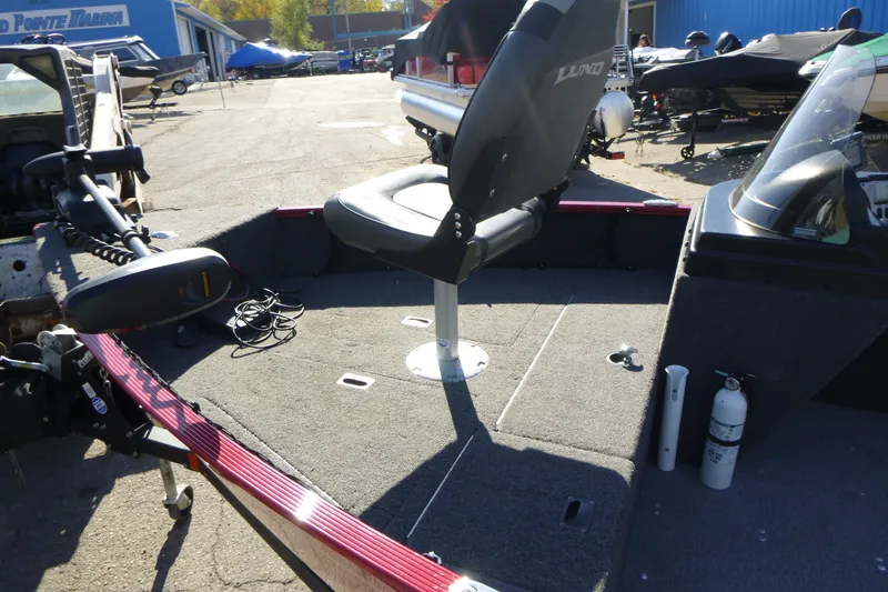 Slide: The Image of 2022 Lund 1650 Angler SS boat interior with seating and equipment at a marina. - 8