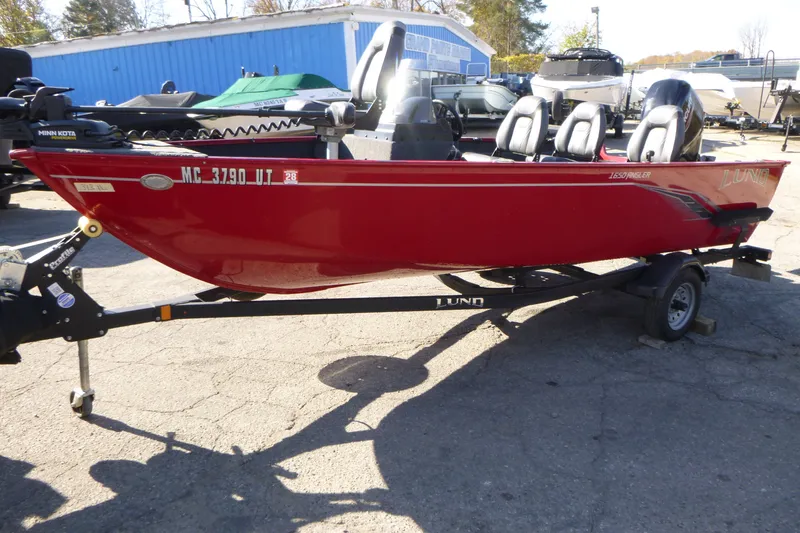 Slide: The Image of Red 2022 Lund 1650 Angler SS boat on trailer, parked outdoors. - 5