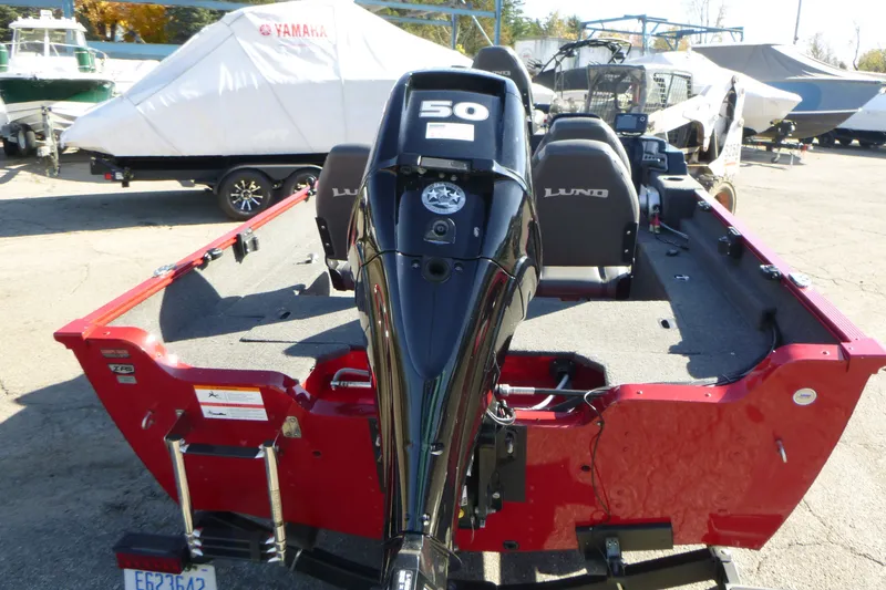 Slide: The Image of 2022 Lund 1650 Angler SS boat with 50 HP motor, red exterior, parked outdoors. - 3