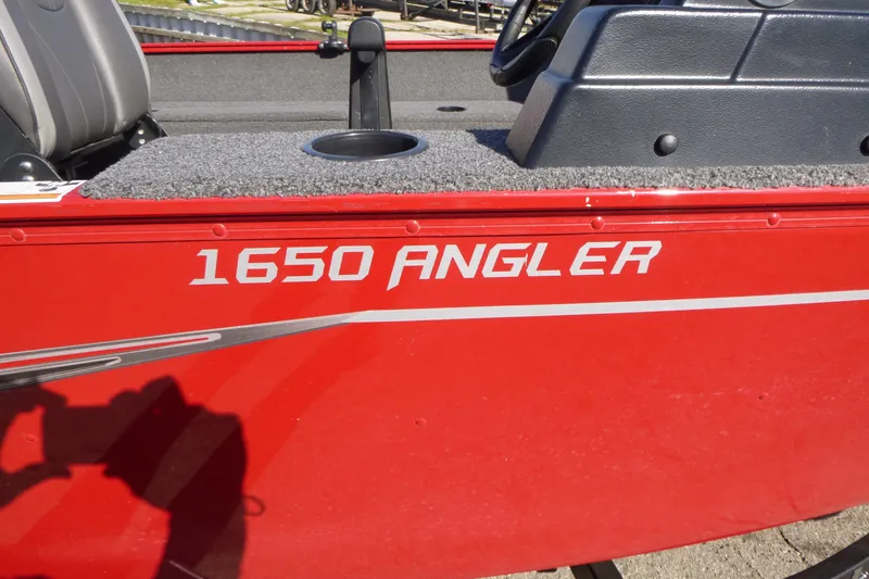 Slide: The Image of Red 2022 Lund 1650 Angler SS boat with gray interior and cup holder. - 13
