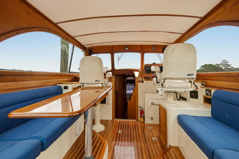 Slide: The Image of Interior of 2002 Hinckley Talaria 44 Flybridge with wooden finish and blue seating. - 25