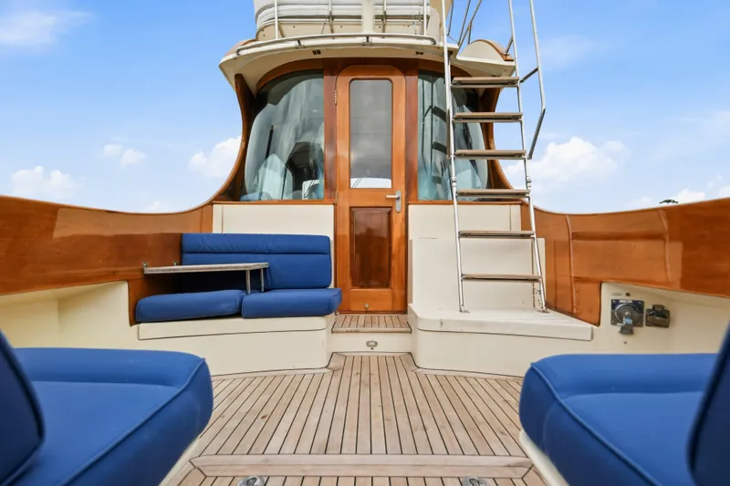 Slide: The Image of Hinckley Talaria 44 Flybridge 2002 yacht with blue seating and wooden deck. - 7