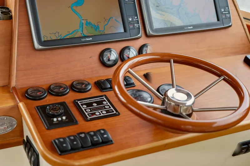 Slide: The Image of Helm of 2002 Hinckley Talaria 44 Flybridge with navigation screens and wooden steering wheel. - 23