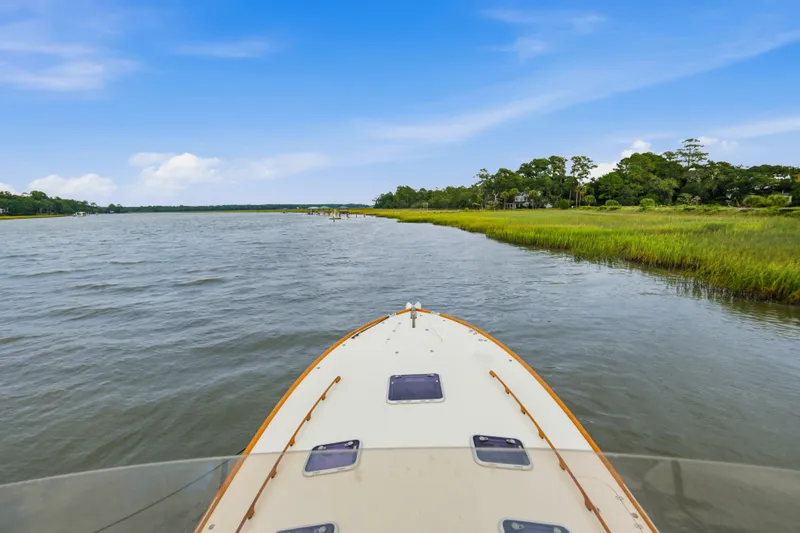 Slide: The Image of Bow view of 2002 Hinckley Talaria 44 Flybridge cruising on a scenic river. - 39