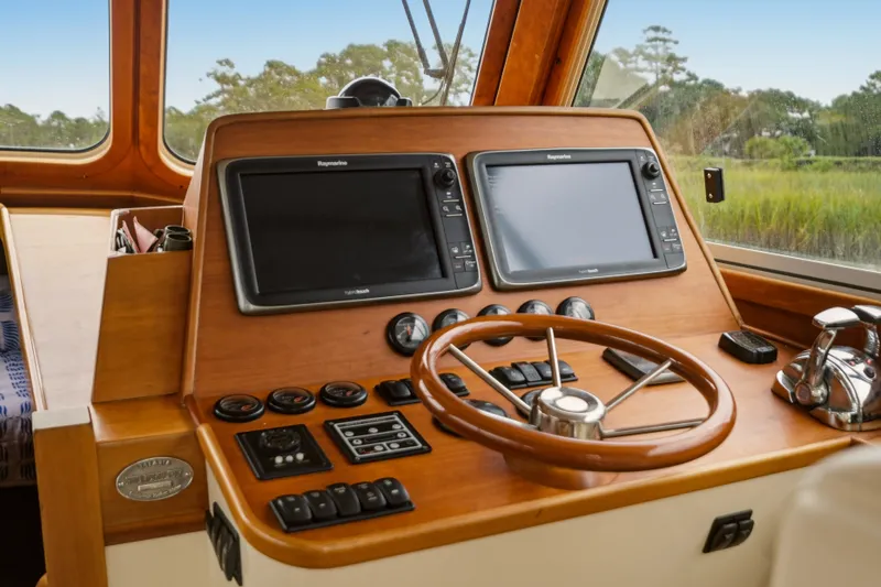 Slide: The Image of Helm of 2002 Hinckley Talaria 44 Flybridge with dual Raymarine displays and wooden steering wheel. - 20