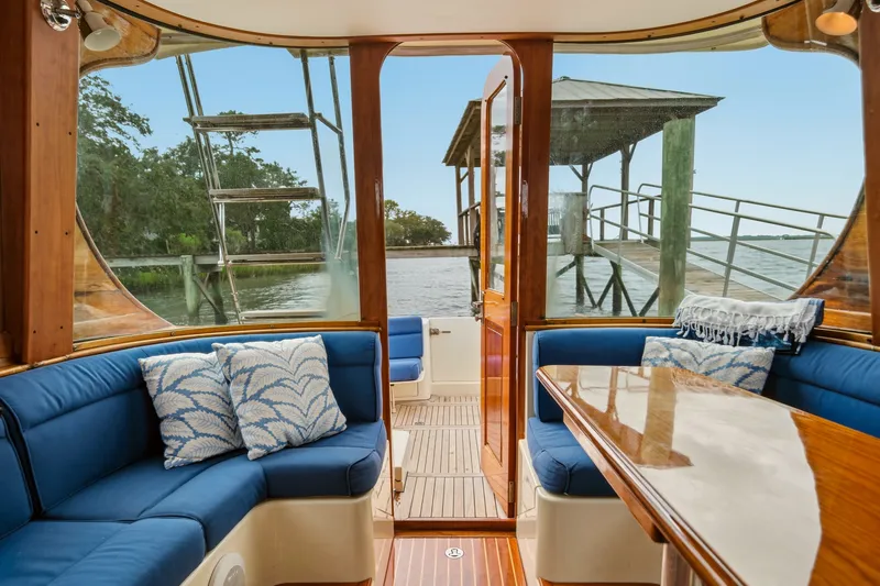 Slide: The Image of Interior of 2002 Hinckley Talaria 44 Flybridge with blue seating and wooden accents. - 13