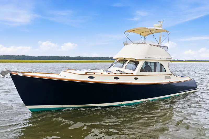 Slide: The Image of 2002 Hinckley Talaria 44 Flybridge yacht cruising on open water under blue sky. - 3