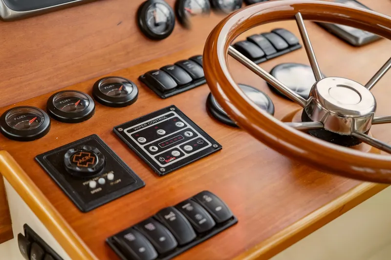 Slide: The Image of Hinckley Talaria 44 Flybridge 2002 helm with wooden steering wheel and control panel. - 24