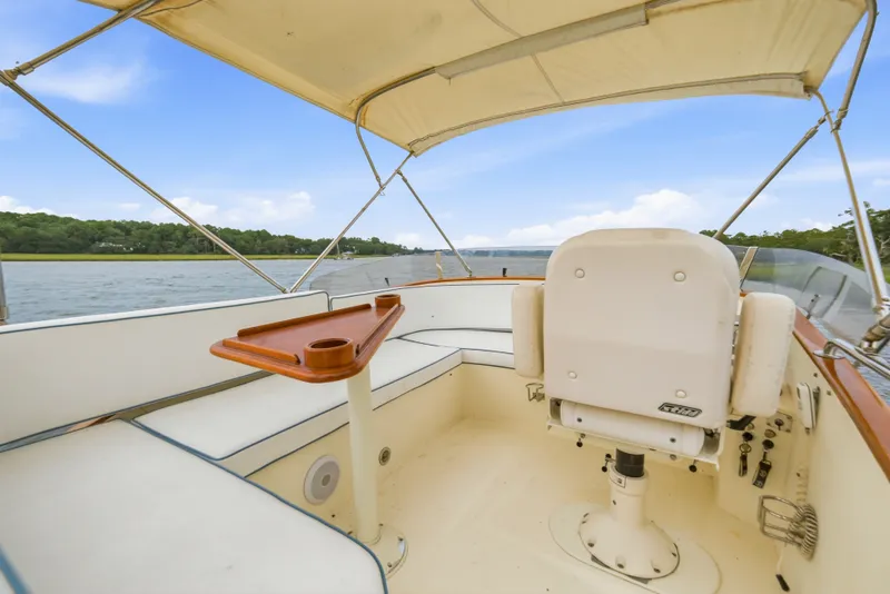 Slide: The Image of Hinckley Talaria 44 Flybridge 2002, featuring a spacious helm with seating and canopy. - 8