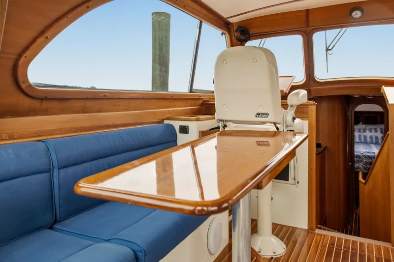 Slide: The Image of Interior of 2002 Hinckley Talaria 44 Flybridge with wooden table and blue seating. - 11