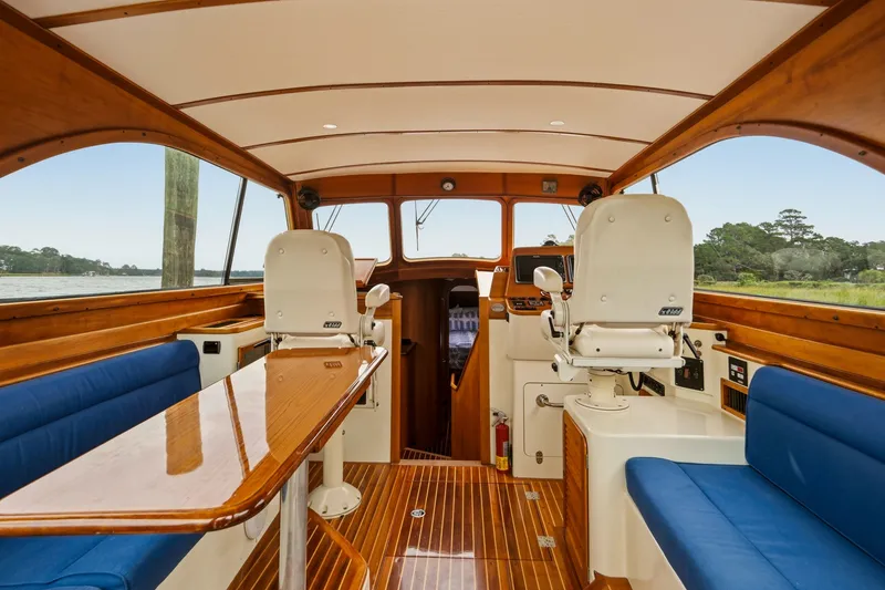 Slide: The Image of Interior of 2002 Hinckley Talaria 44 Flybridge with wooden finishes and blue seating. - 10