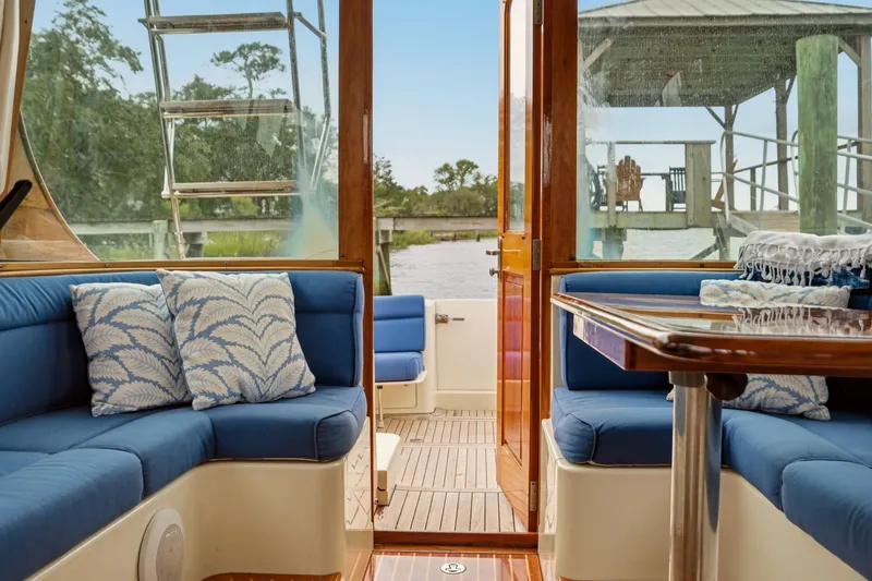Slide: The Image of Interior of 2002 Hinckley Talaria 44 Flybridge with blue seating and decorative pillows. - 14