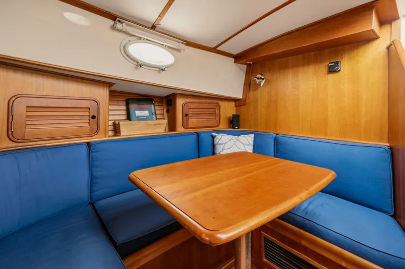 Slide: The Image of Interior of 2002 Hinckley Talaria 44 Flybridge with blue seating and wooden table. - 30