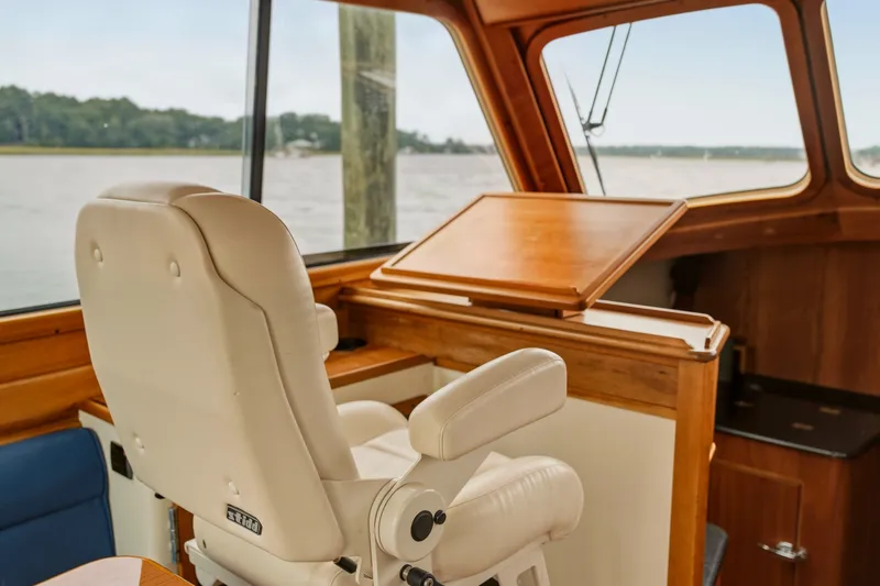 Slide: The Image of Interior of 2002 Hinckley Talaria 44 Flybridge with captain's chair and wooden dashboard. - 18