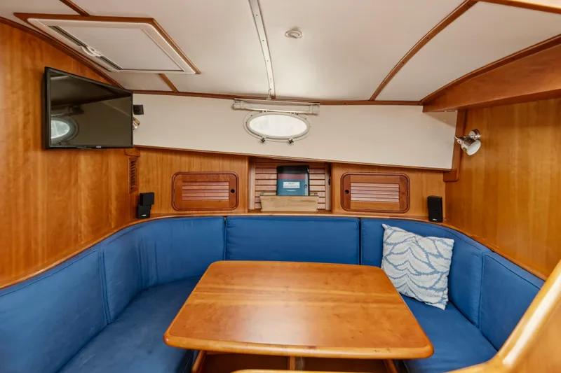 Slide: The Image of Interior of 2002 Hinckley Talaria 44 Flybridge with blue seating and wooden table. - 31
