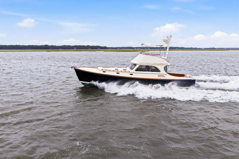 Slide: The Image of 2002 Hinckley Talaria 44 Flybridge cruising on open water under a clear sky. - 43