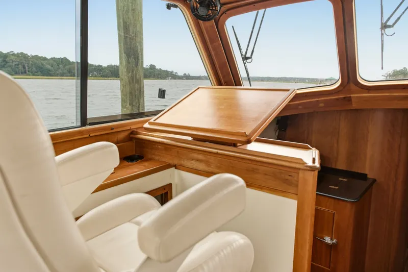 Slide: The Image of Interior of 2002 Hinckley Talaria 44 Flybridge with wooden helm and white seating. - 17