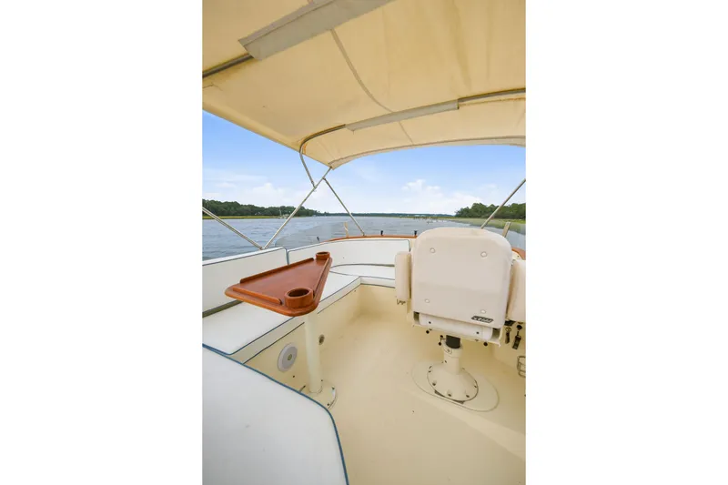 Slide: The Image of 2002 Hinckley Talaria 44 Flybridge interior with helm seat and water view. - 9