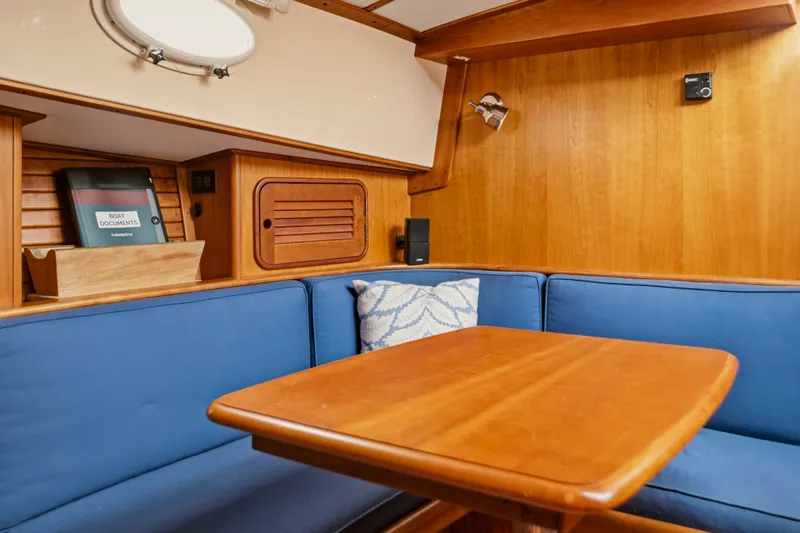 Slide: The Image of Interior of 2002 Hinckley Talaria 44 Flybridge with wooden table and blue seating. - 32