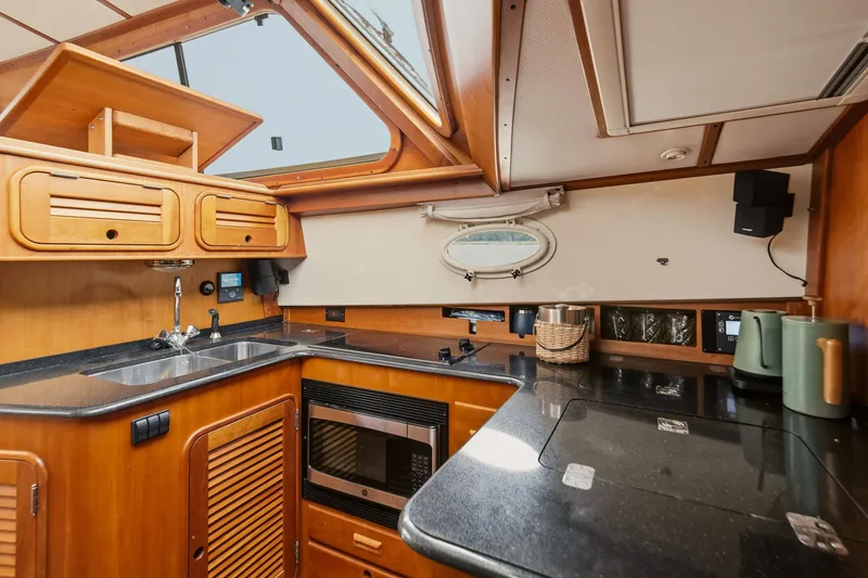Slide: The Image of Hinckley Talaria 44 Flybridge 2002 yacht kitchen with wood cabinetry and modern appliances. - 29