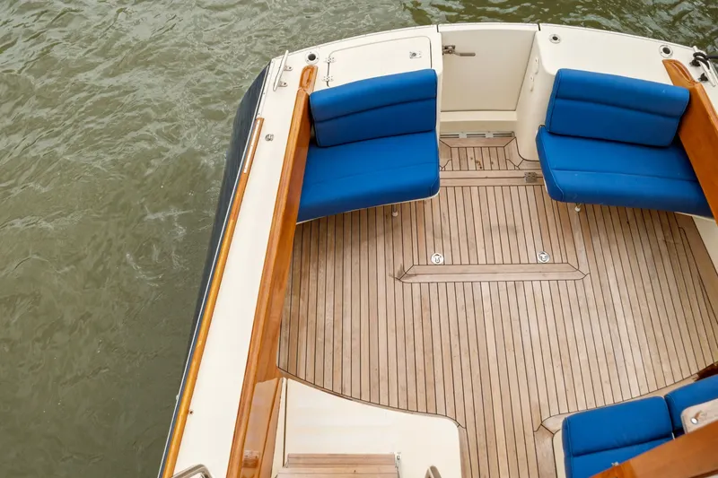 Slide: The Image of Hinckley Talaria 44 Flybridge 2002 boat deck with blue seating and wooden flooring. - 5