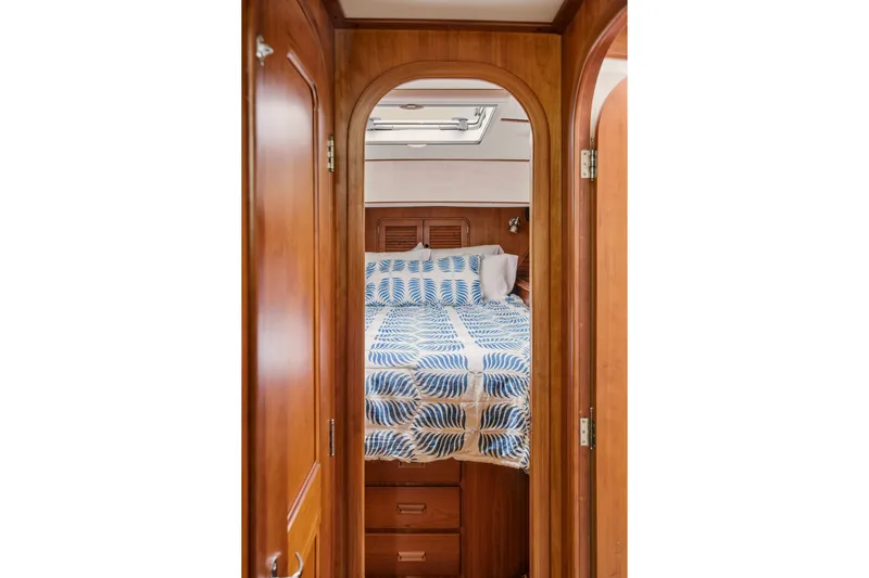 Slide: The Image of Hinckley Talaria 44 Flybridge 2002 cabin interior with wooden finish and patterned bedding. - 34