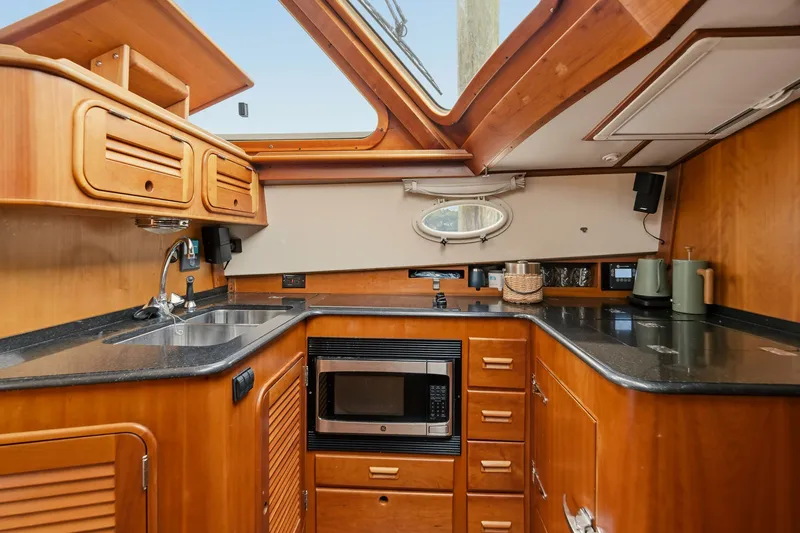 Slide: The Image of Hinckley Talaria 44 Flybridge 2002 yacht kitchen with wood cabinetry and modern appliances. - 28