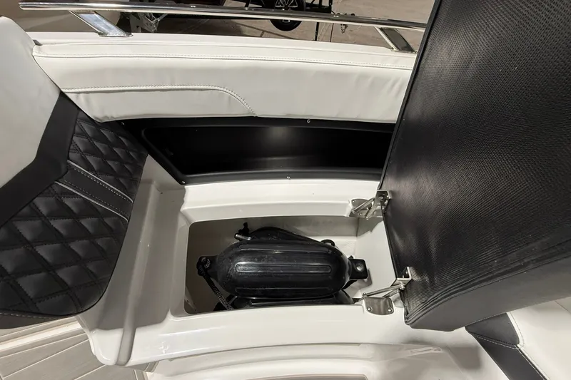Slide: The Image of Open storage compartment in 2025 Monterey Elite 27 OB boat with black and white seating. - 36