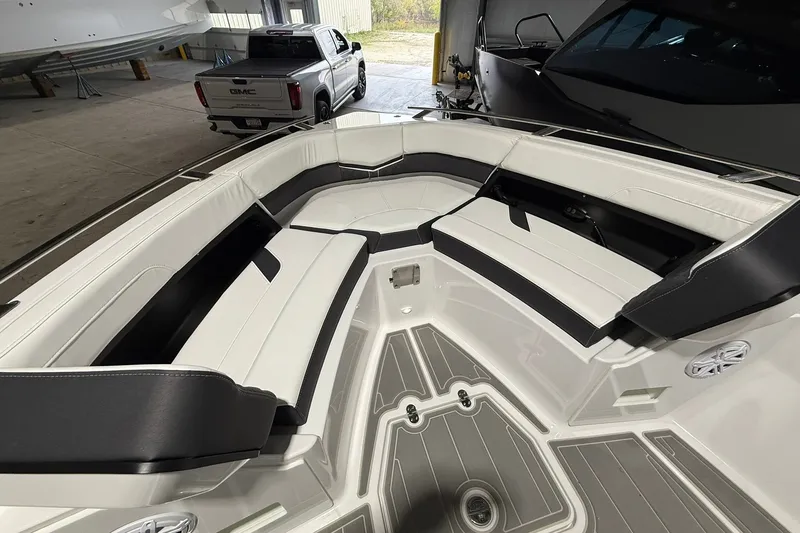 Slide: The Image of 2025 Monterey Elite 27 OB boat interior with sleek white and black seating in a garage. - 33