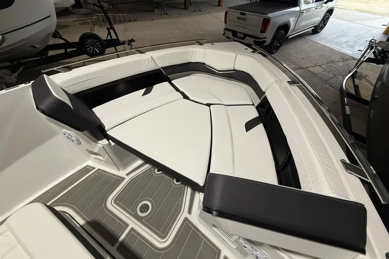 Slide: The Image of 2025 Monterey Elite 27 OB boat interior with white and black seating, parked in a garage. - 30
