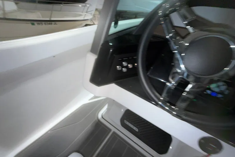 Slide: The Image of Interior view of 2025 Monterey Elite 27 OB boat steering wheel and dashboard. - 27