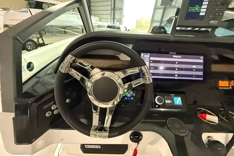 Slide: The Image of Steering console of 2025 Monterey Elite 27 OB boat with advanced navigation display. - 26