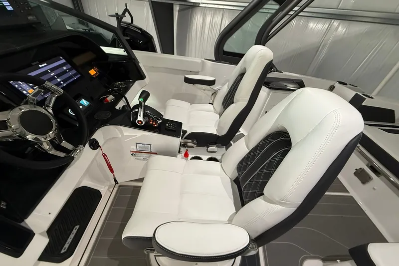 Slide: The Image of Interior of 2025 Monterey Elite 27 OB boat with modern dashboard and white seating. - 20