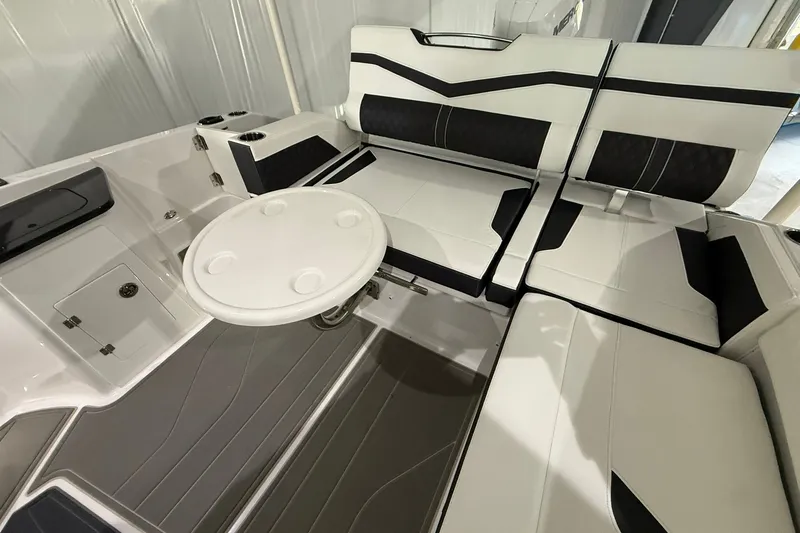 Slide: The Image of 2025 Monterey Elite 27 OB boat interior with sleek seating and round table. - 44