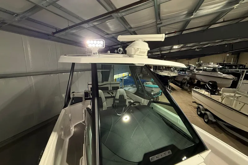 Slide: The Image of 2025 Monterey Elite 27 OB boat in a showroom, featuring sleek design and modern lighting. - 32
