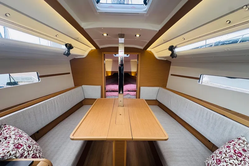 Slide: The Image of 2024 Jeanneau Sun Odyssey 349 interior with cozy seating and wooden table. - 39