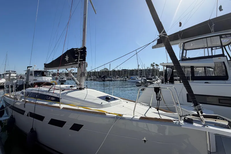 Slide: The Image of 2024 Jeanneau Sun Odyssey 349 sailboat docked in a marina under clear blue skies. - 12