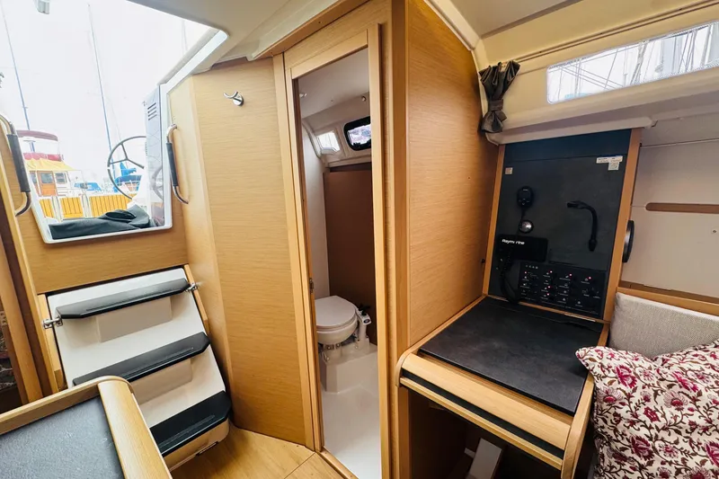 Slide: The Image of 2024 Jeanneau Sun Odyssey 349 interior with navigation station and compact bathroom. - 54