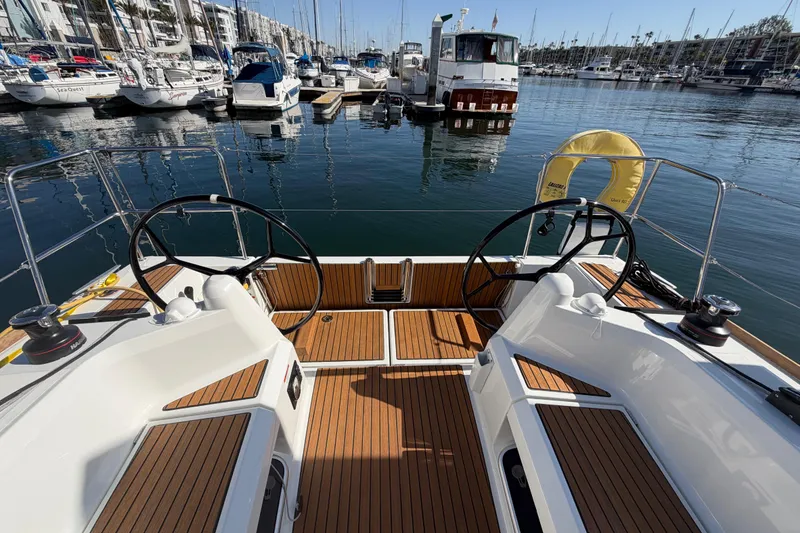 Slide: The Image of 2024 Jeanneau Sun Odyssey 349 sailboat cockpit with dual steering wheels in marina. - 29