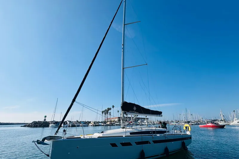 Slide: The Image of 2024 Jeanneau Sun Odyssey 349 sailboat docked in a marina under clear blue skies. - 3