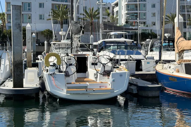 Slide: The Image of 2024 Jeanneau Sun Odyssey 349 sailboat docked in a marina, surrounded by other boats. - 35