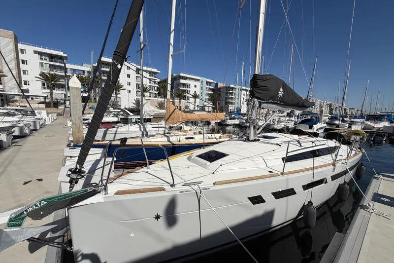 Slide: The Image of 2024 Jeanneau Sun Odyssey 349 sailboat docked in a marina under clear blue skies. - 14