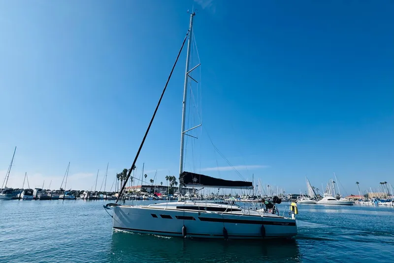 Slide: The Image of 2024 Jeanneau Sun Odyssey 349 sailboat in a marina under clear blue skies. - 5